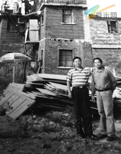 2009年，张安房（左）和朋友在老屋前合影，他家已被停水断电一年。